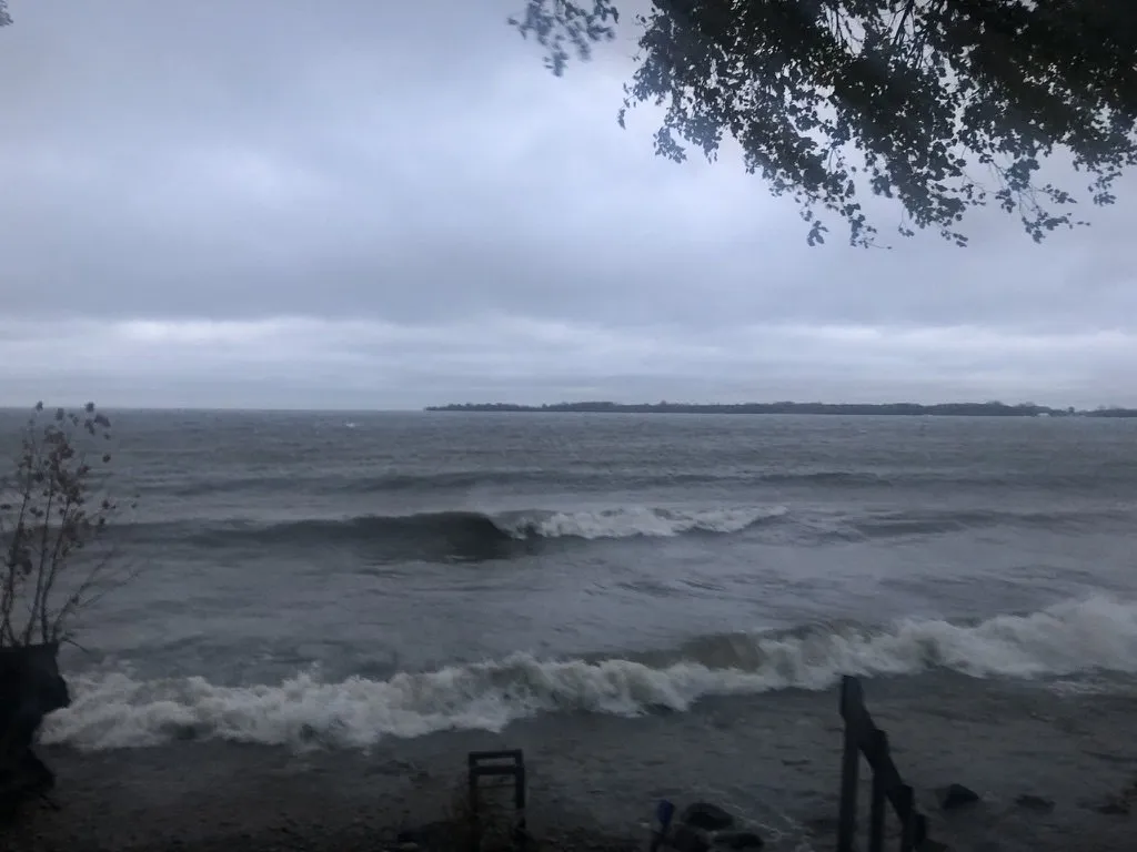 Grey storm waves breaking on the shore, an island behind